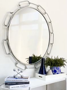 a white table topped with a mirror and vases