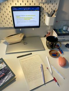 a desktop computer sitting on top of a desk next to a notebook and pen holder