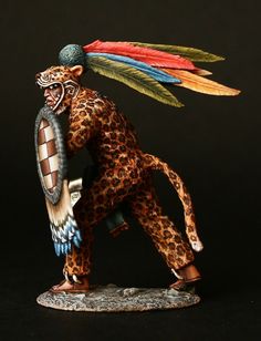 a figurine of a man with feathers on his head and leopard print body