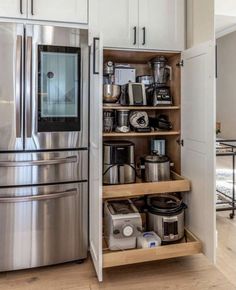 a kitchen with stainless steel appliances and wooden shelves filled with pots, pans, and other items