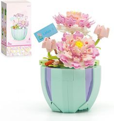 there is a flower pot with flowers in it and a card on the box next to it