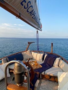 the deck of a sailboat with cushions and pillows on it's back end