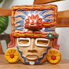 a ceramic mask sitting on top of a wooden table