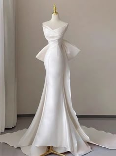 a white wedding dress on display in front of a window