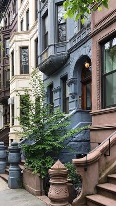 a row of brownstone townhouses with stone steps leading up to the front door