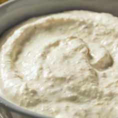 a bowl filled with white sauce sitting on top of a table