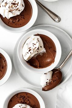 three white bowls filled with chocolate pudding and whipped cream