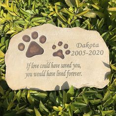 a memorial stone with two paw prints on it and the words, dakota 200 - 2050