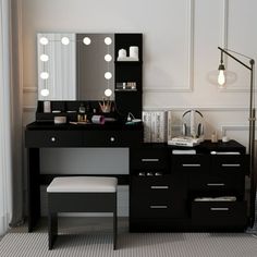 a black vanity with lights on it and a stool