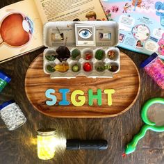 an assortment of toys and children's books sitting on a table with the word sight spelled out