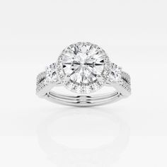 a white gold ring with diamonds on the band and an oval center stone in the middle