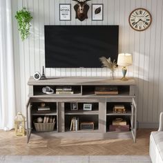 a living room with an entertainment center and large clock on the wall above it's door