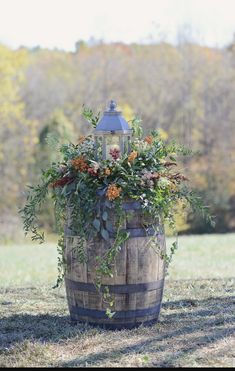 a wooden barrel filled with flowers and greenery