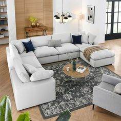 a living room filled with white furniture and wooden floors