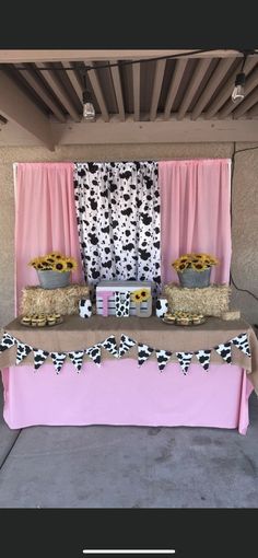 the table is set up with pink and black decorations, including sunflowers on it