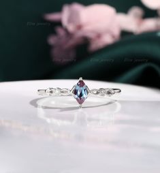 a white gold ring with a blue topazte and diamonds on it's side