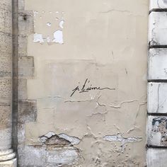 the corner of an old building with graffiti on it's wall and door frame