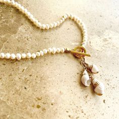 For those who prefer smaller pearls this beach inspired boho style fashion piece features dainty Grade A freshwater pearls finished with a 24k gold plated toggle clasp and trio of tiny seashell charms.  This necklace has been hand knotted for the best quality finish and comes in a classic 17" length. Perfect for Summer it's a timeless design that works for every occasion. Wear alone or layer with your other pieces to create a more casual bohemian style. Also makes a gorgeous gift ❤️ Presented in Luxury White Shell Necklace With Pearl Charm, Casual Bohemian Style, Spiral Shell, Pearls Necklace, Shell Jewelry, Freshwater Cultured Pearls, Beach Inspired, Gorgeous Gift, Toggle Clasp