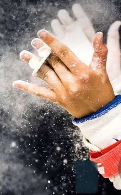 a person's hand holding something in the air with snow falling around them and on top of it