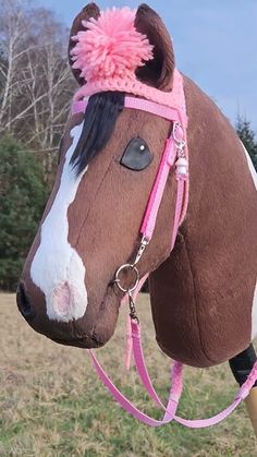 a brown and white horse with a pink bridle on it's head