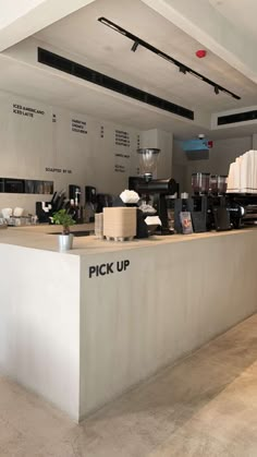 the inside of a coffee shop with white counter tops and black letters on the wall