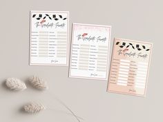 two wedding seating cards with feathers on them next to some dried flowers and grass in front of it