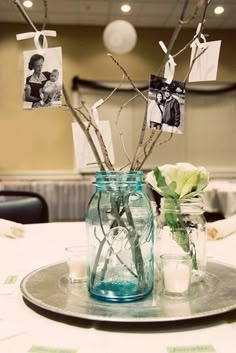 two vases filled with flowers on top of a table covered in cards and photos