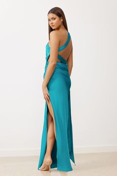 The Marella Dress features an elegant one shoulder design leading to a sexy open back, paired with a dramatic crossover sash. The ankle length dress is crafted from a luxe heavyweight recycled satin, showcasing a thigh high split and beautifully draped cowl at the back waist. The flattering tucks, carefully positioned at the waist side seam, compliments the figure, creating the ultimate classy look. Open back with adjustable crossover sash Sash can be worn in multiple ways Adjustable spaghetti s Satin Gown With Side Slits For Gala, Formal Satin Gown With Side Slits, Backless Satin Evening Maxi Dress, Glamorous Satin Dress With Side Slits, One-shoulder Satin Maxi Dress With Sweep Train, Floor-length Maxi Dress With Crisscross Straps For Evening, Backless Satin Maxi Dress For Gala, Backless Satin Maxi Dress For Prom Season, Evening Gown With Side Slits In Satin