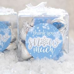 two clear boxes filled with blue and white christmas ornaments sitting on top of snow covered ground