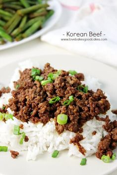 a white plate topped with rice and ground beef next to green bean sprouts