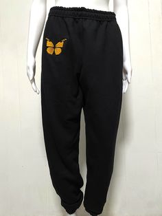 A beautiful black and orange monarch butterfly embroidered onto some comfy sweatpants. Wear it as pajamas, for running, dancing, skating, and more!  SPECS: -Embroidered -Fruit of the loom Sweatpants (Light to Mid weight 8oz) -60% Cotton, 40% Polyester -Design is 3.9x3.5in -Quick and Quality Production! **if chosen Size & Color sweatpants aren't available - Hanes brand sweatpants will be used instead  (Any questions please reach out!  Designed by me! Cece :) Instagram.com/cecespatchedprints ----- Butterfly Pants, Comfort Gifts, Comfy Sweatpants, Sweat Joggers, Monarch Butterfly, Fruit Of The Loom, Custom Embroidery, Jogging, Pajamas