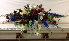 a casket with flowers and greenery on it