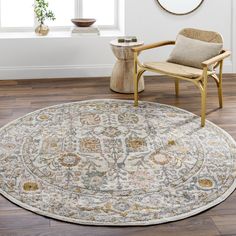 a large round rug with an ornate design on the floor in front of a window