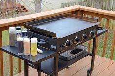 an outdoor grill on a deck with cleaning products