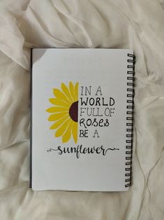 a notebook with the words in a world full of roses be a sunflower