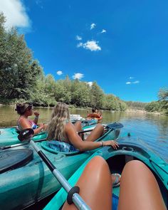 two women are sitting in their kayaks on the water, and one woman is looking back