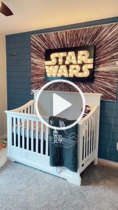 a baby's room with a star wars theme on the wall and a white crib