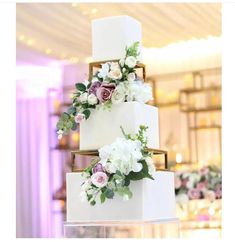 a three tiered white wedding cake with flowers on top