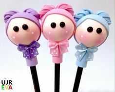 three cake pops with bows on them are in the shape of two girls'heads