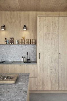 a kitchen with wooden cabinets and marble counter tops