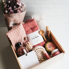 a wooden box filled with lots of different items next to a potted plant on top of a table