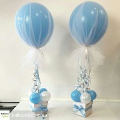 two blue and white balloons are attached to small gift boxes with ribbons, bows and streamers