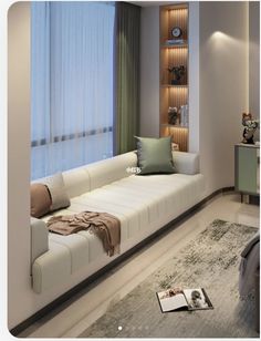 a living room with a white couch next to a window and a book shelf on the wall