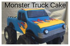 a blue monster truck cake sitting on top of a white tablecloth covered table with the words monster truck cake written across it