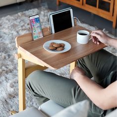 a person sitting at a table with a plate of cookies and an ipad on it