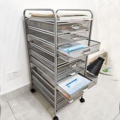 a metal filing cart with five drawers on wheels