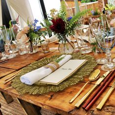 a wooden table topped with lots of place settings