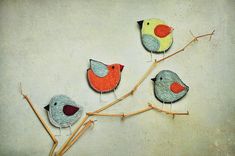 three birds sitting on top of a tree branch with one red and the other blue