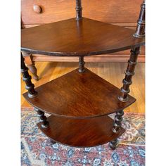 two tiered wooden shelf on top of a rug