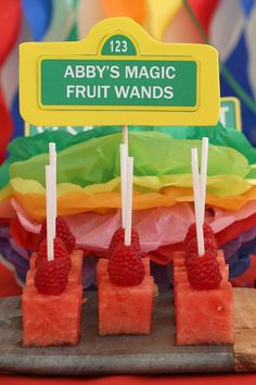 there are three popsicles with raspberries on them and a sign that says aby's magic fruit wands